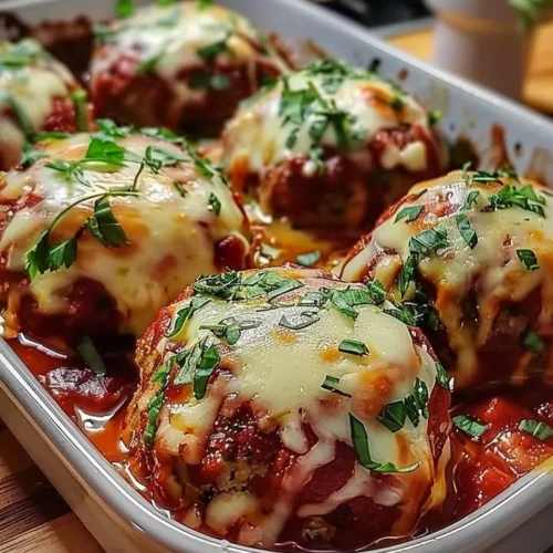 Baked mozzarella stuffed meatballs fresh out of the oven, gooey cheese inside.