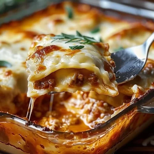 Baked ravioli casserole served in a dish, topped with cheese and herbs.