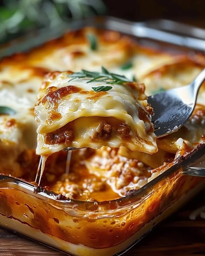 Baked ravioli casserole served in a dish, topped with cheese and herbs.
