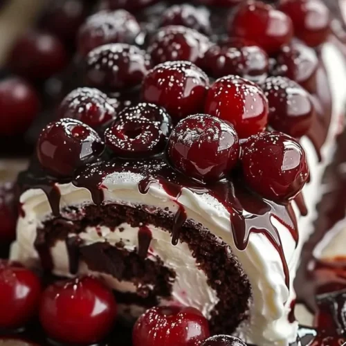 Delicious Black Forest Swiss Roll with cherries and cream on a plate