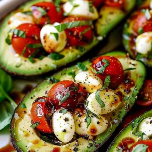 Caprese stuffed avocado with tomatoes and basil on a plate