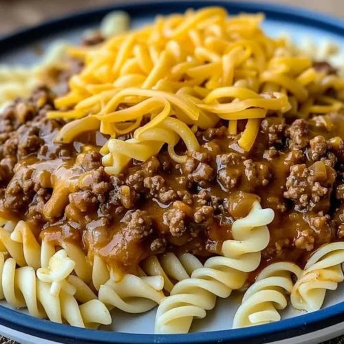 A bowl of Cheesy Sloppy Cheeseburger Pasta topped with melted cheese and fresh parsley