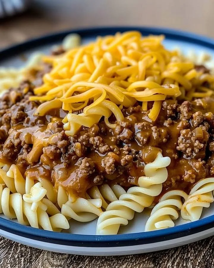 A bowl of Cheesy Sloppy Cheeseburger Pasta topped with melted cheese and fresh parsley