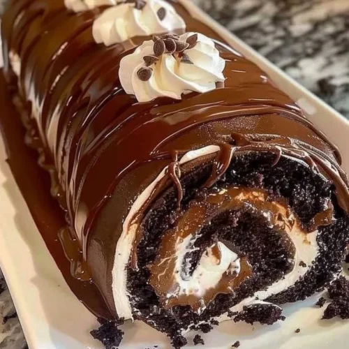 Decadent chocolate cake roll garnished with cocoa powder and cream