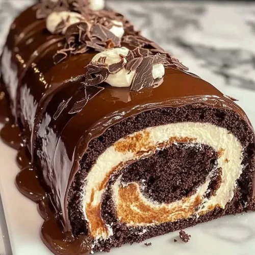 Delicious Chocolate Cake Roll topped with creamy frosting and garnished with chocolate shavings