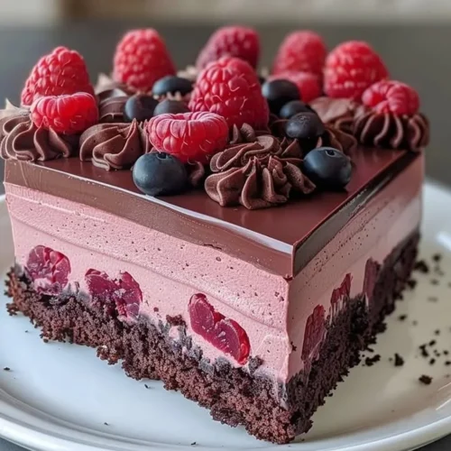 Slice of rich Chocolate Raspberry Mousse Cake with fresh raspberries on top