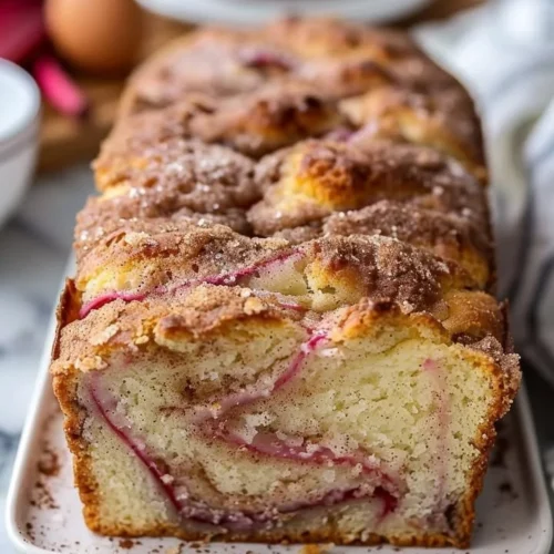 A delicious loaf of Cinnamon Swirl Rhubarb Bread with cinnamon swirls and chunks of rhubarb.