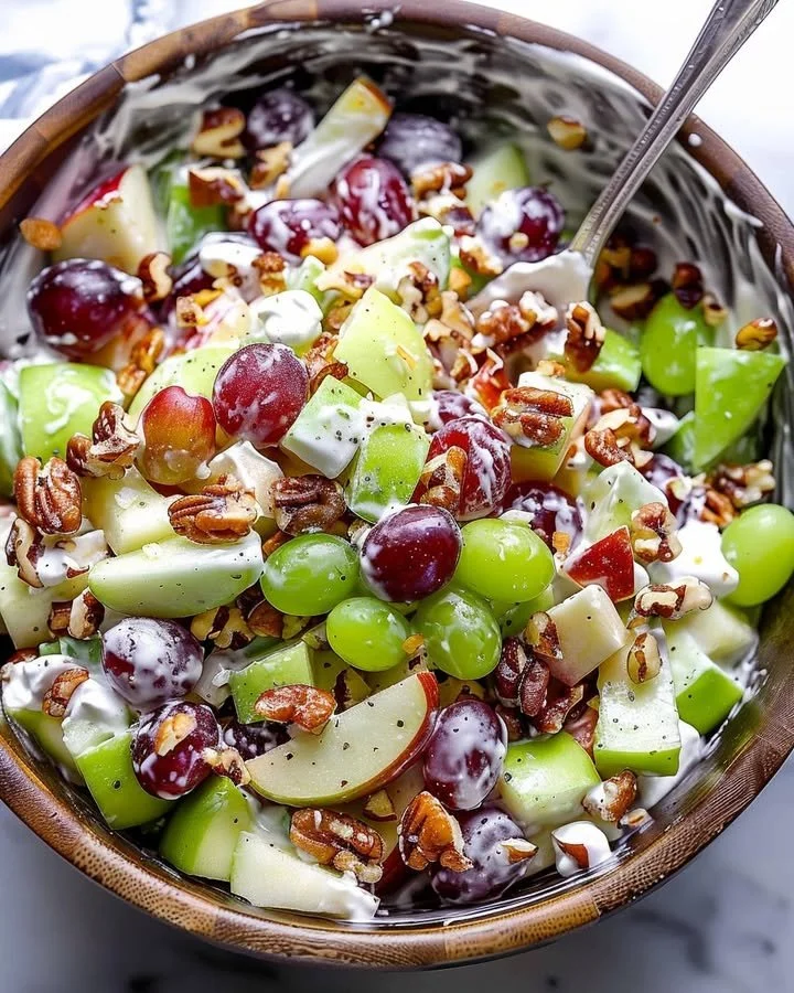 Classic Waldorf salad with apples, walnuts, and celery on a plate.