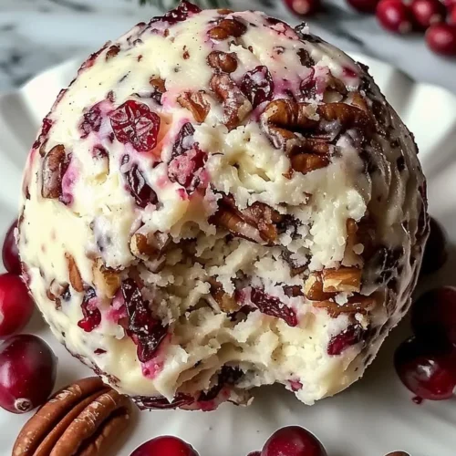 Cranberry Pecan Cheese Ball served on a wooden platter with crackers.