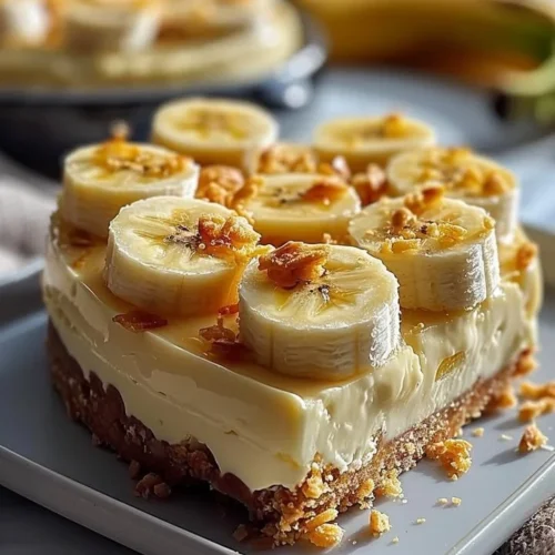 Slice of creamy banana cheesecake topped with banana slices and whipped cream