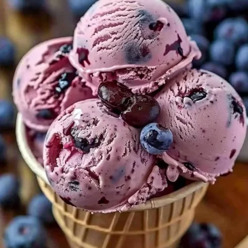 Delicious Crimson Choco Rhapsody Ice Cream in a cone topped with chocolate syrup.