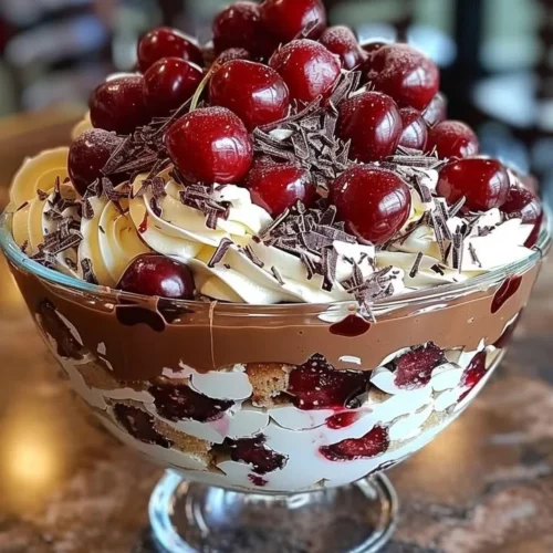 Decadent cherry chocolate trifle layered with cherries and chocolate cream.