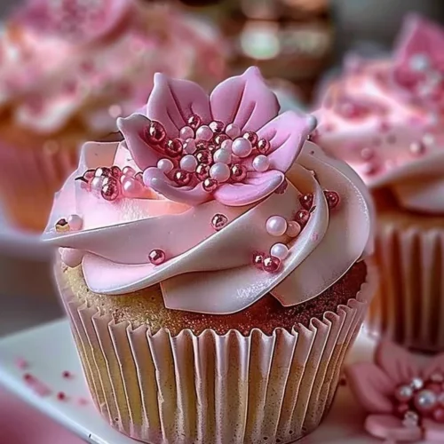 Elegant pink buttercream cupcakes decorated with delicate sprinkles.