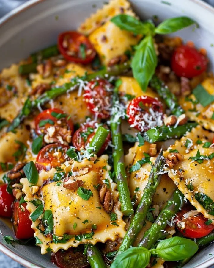 Plate of garden fresh asparagus tomato ravioli tossed with herbs and olive oil