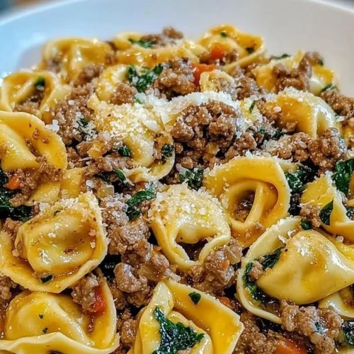 Plate of garlic butter beef tortellini garnished with herbs