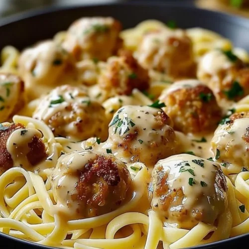 Garlic butter chicken bites served with creamy parmesan pasta in a bowl.