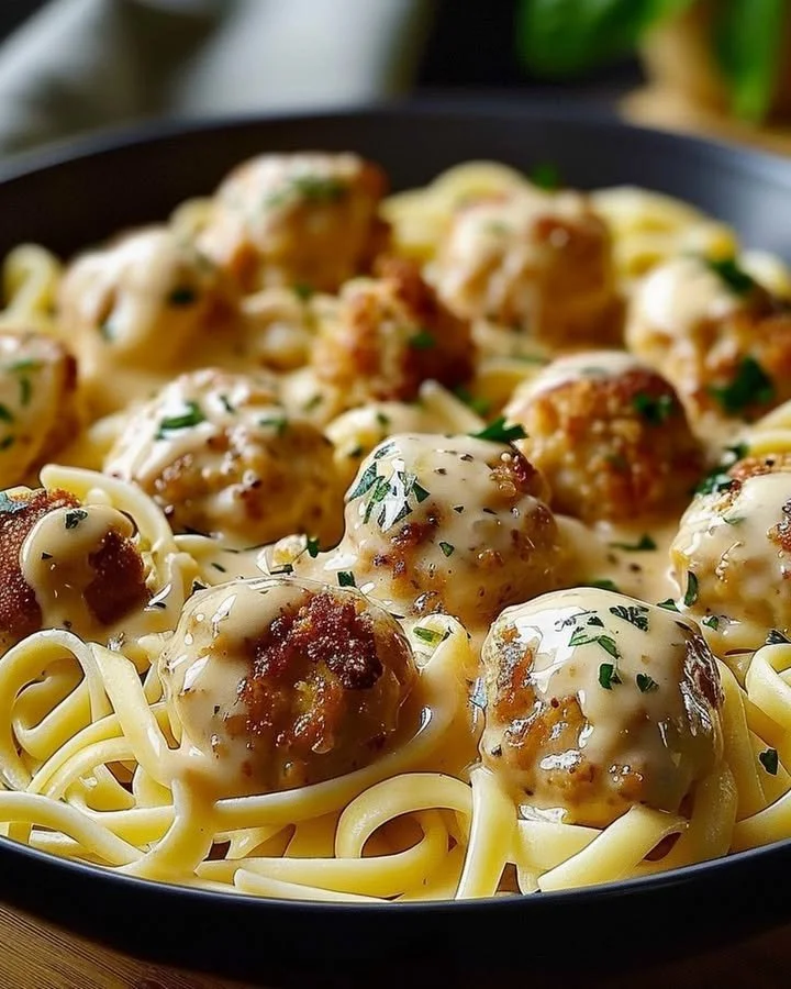 Garlic butter chicken bites served with creamy parmesan pasta in a bowl.