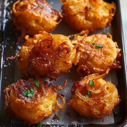 Plate of crispy golden onion fritters ready to serve.