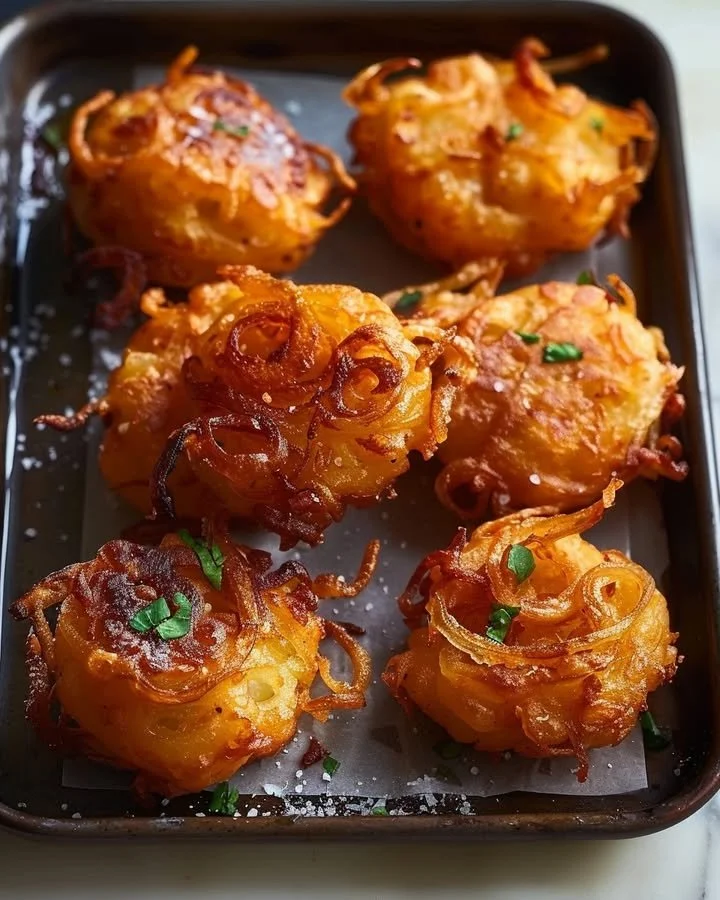 Plate of crispy golden onion fritters ready to serve.