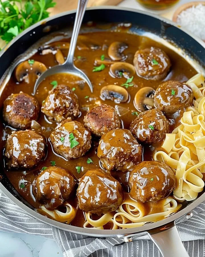 Gourmet meatballs served with rich mushroom gravy on a plate.