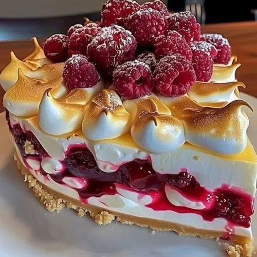 Heavenly Lemon Raspberry Meringue Cheesecake topped with light, fluffy meringue.