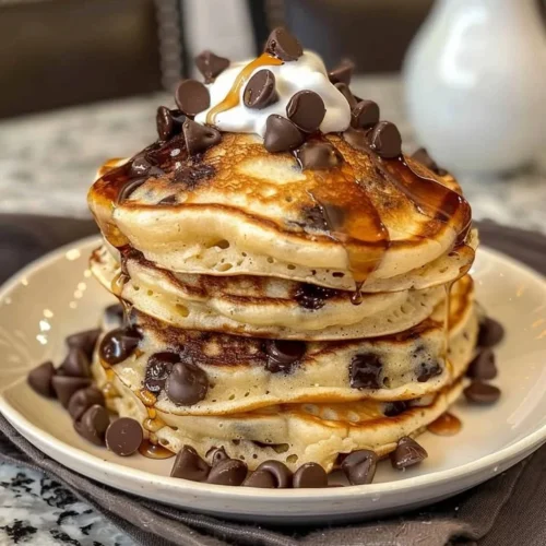 Delicious Heavenly Morsels chocolate pancakes topped with whipped cream and chocolate syrup.
