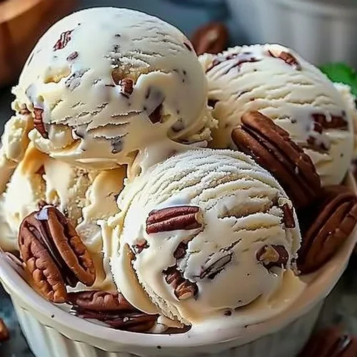 Bowl of homemade butter pecan ice cream topped with roasted pecans