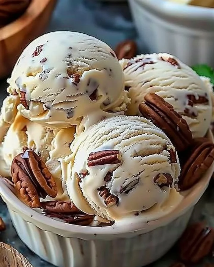 Bowl of homemade butter pecan ice cream topped with roasted pecans