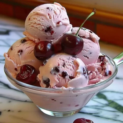 Creamy homemade cherry ice cream topped with fresh cherries