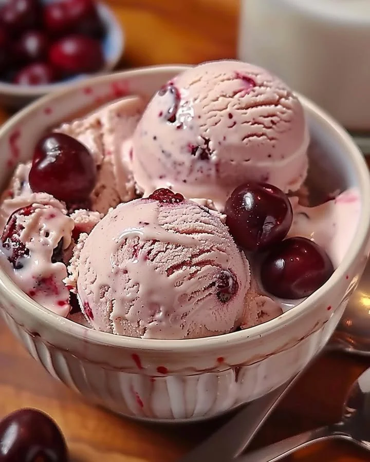 A bowl of homemade cherry vanilla ice cream topped with fresh cherries