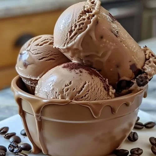 Bowl of homemade coffee ice cream topped with coffee beans and chocolate curls