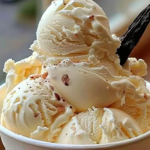 Bowl of homemade vanilla ice cream with fresh mint leaves on top
