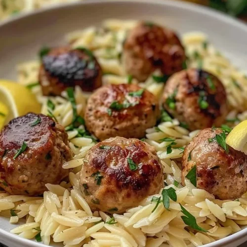 Lemon chicken ricotta meatballs served with garlic orzo on a plate