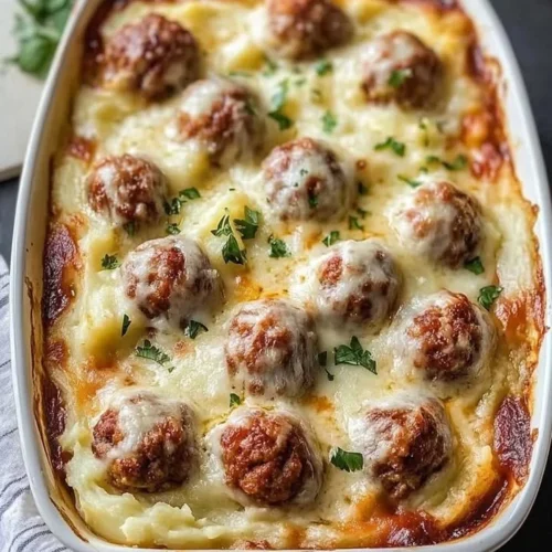 Loaded mashed potatoes casserole topped with meatballs and cheese