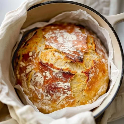 Freshly baked no knead artisan bread loaf on a wooden table