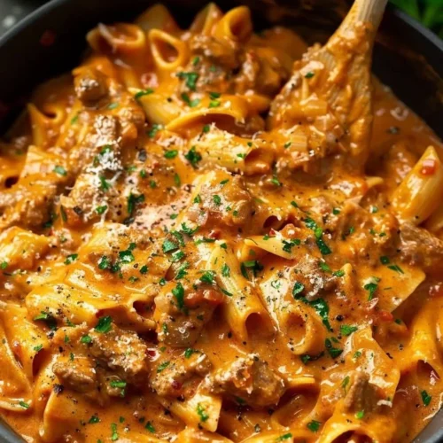 One Pot Creamy Beef Pasta in a serving dish with herbs and cheese