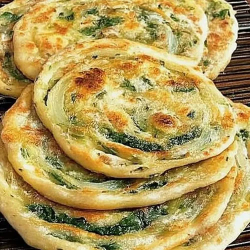 Pan-fried green onion and spinach flatbread served on a plate