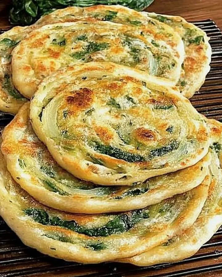 Pan-fried green onion and spinach flatbread served on a plate