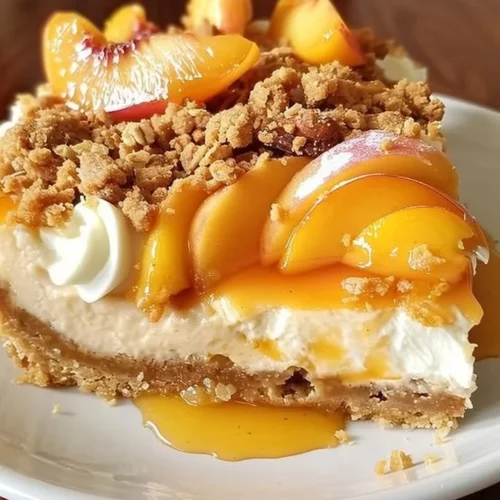 Delicious peach cobbler cheesecake topped with fresh peaches and a crispy crust.
