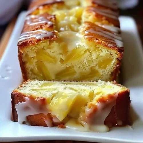 Delicious slice of Pineapple Quick Bread topped with pineapple chunks