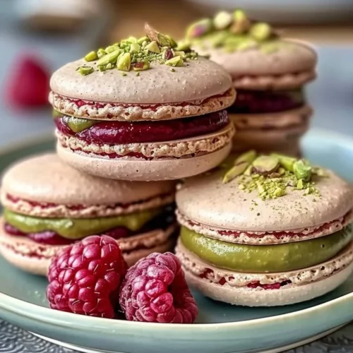 Raspberry Pistachio Macarons freshly baked on a platter