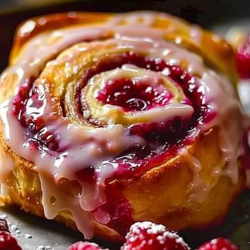 Freshly baked Raspberry Cinnamon Rolls topped with creamy icing