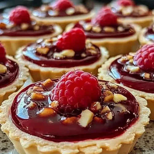 Delicious Raspberry Rhapsody Tarts with fresh raspberries on top