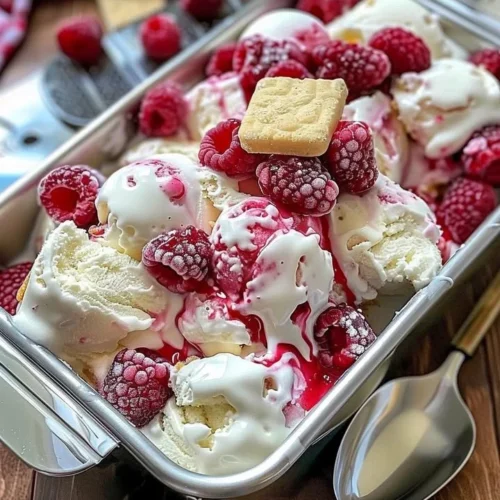 Delicious Raspberry Shortcake Ice Cream served with fresh raspberries and whipped cream.