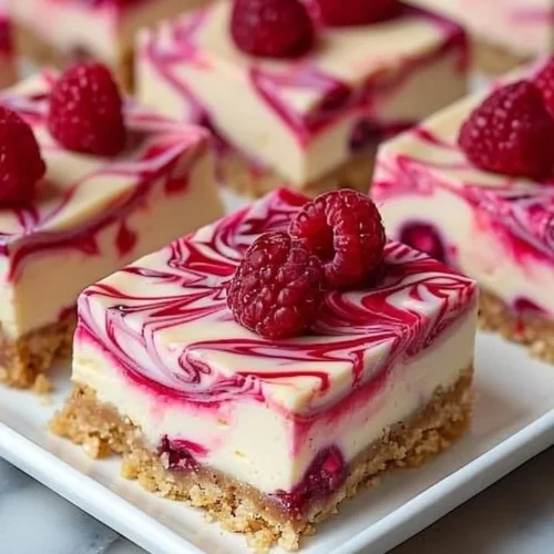 Raspberry Swirl Cheesecake Bars with a creamy texture and vibrant raspberry topping.