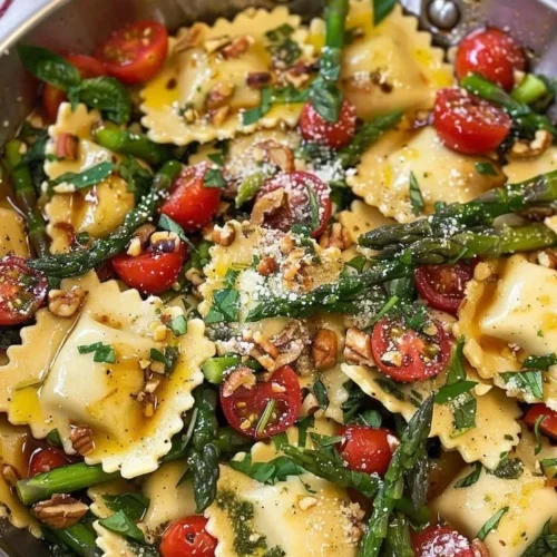 Delicious ravioli topped with tomatoes, asparagus, garlic, and herbs