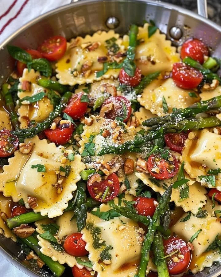 Delicious ravioli topped with tomatoes, asparagus, garlic, and herbs