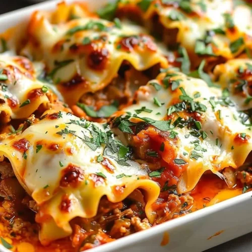 Plate of short rib lasagna rolls with rich beef filling and cheese topping.