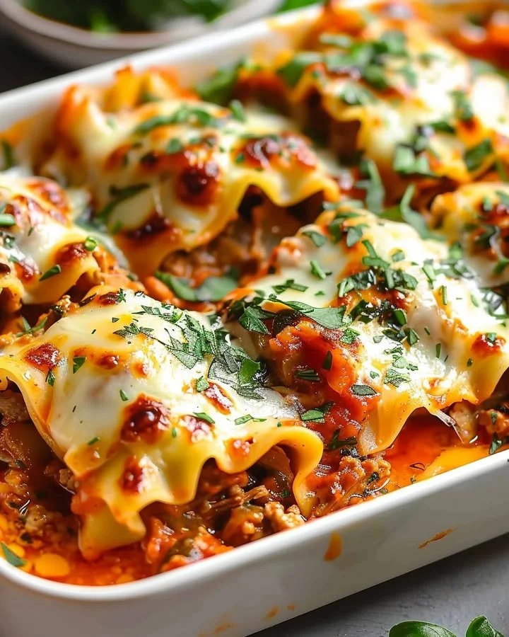 Plate of short rib lasagna rolls with rich beef filling and cheese topping.