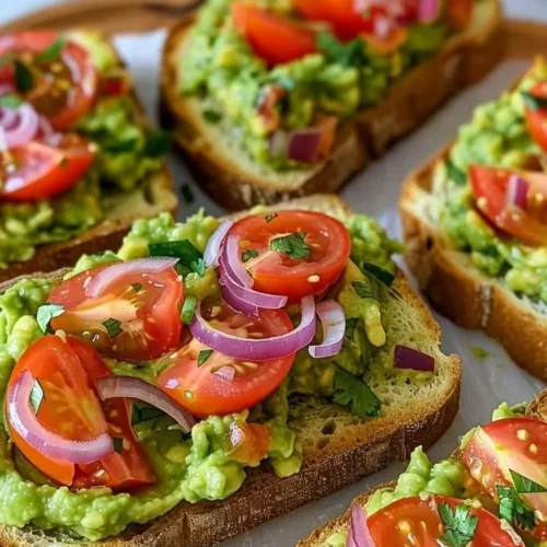 Delicious smashed avocado bruschetta topped with tomatoes and herbs